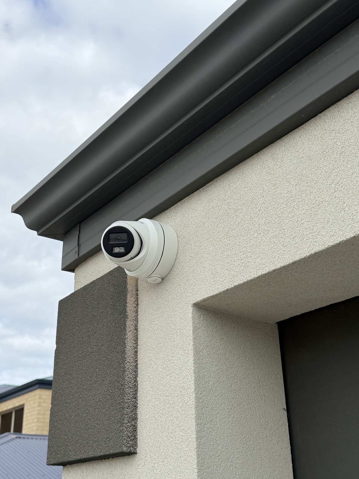 Hikvision turret CCTV camera mounted under eave corner — North Side Security Perth