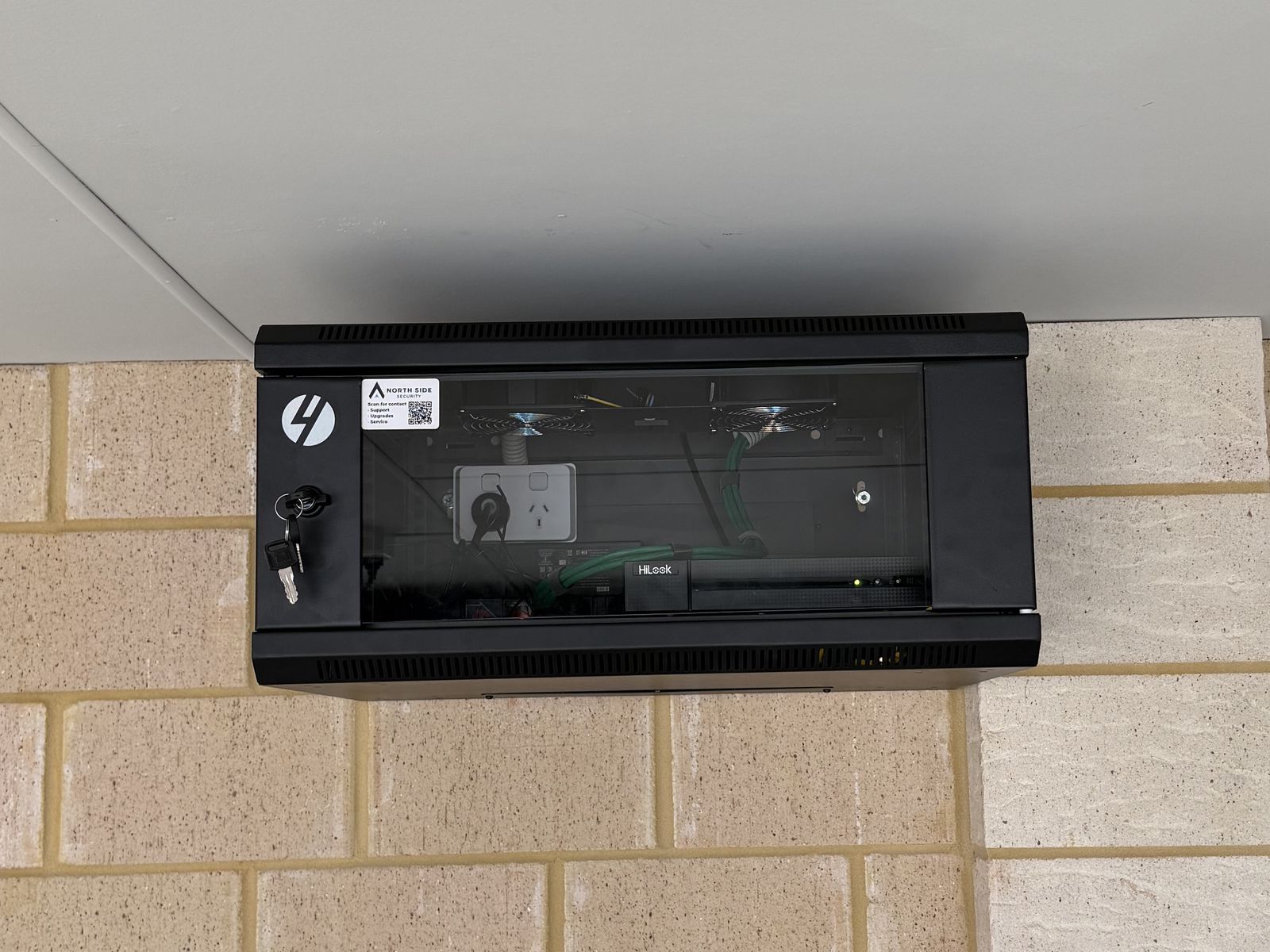 Lockable wall-mounted network rack with a HiLook recorder, installed by North Side Security